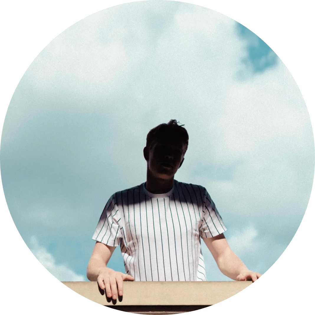 Man wearing a striped shirt against a cloudy background.